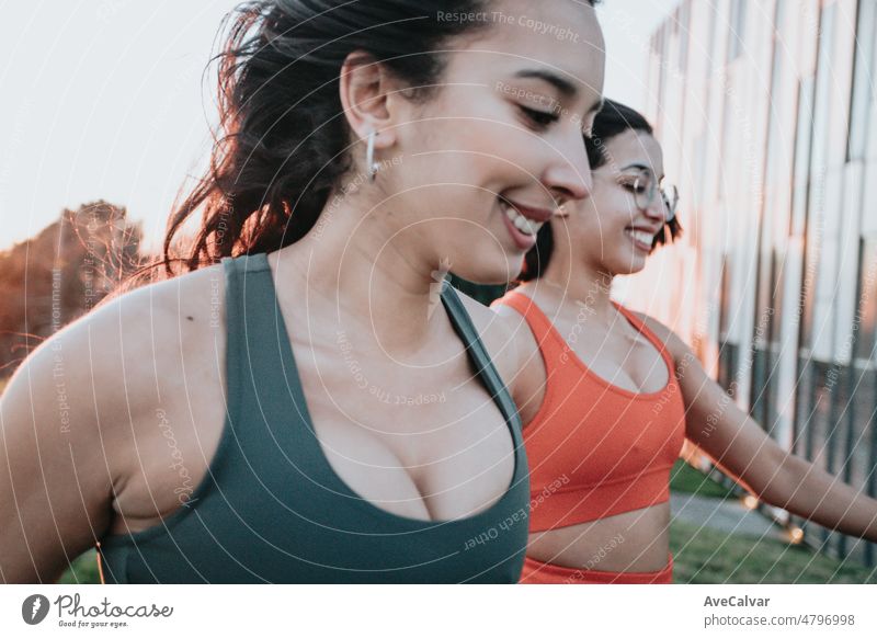 Zwei junge Frauen, die während einer Trainingseinheit im Freien zusammen laufen. Glückliche Freunde trainieren zusammen an einem sonnigen Sommertag und bereiten sich auf den Strandkörper vor