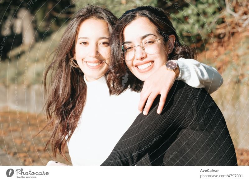 Zwei junge Schwestern umarmen sich im Freien der Universität glücklich, einen neuen Weg auf dem Leben zu beginnen, studieren zusammen. Muslimische marokkanische Mädchen in Europa. Glückliche Integration Konzept.