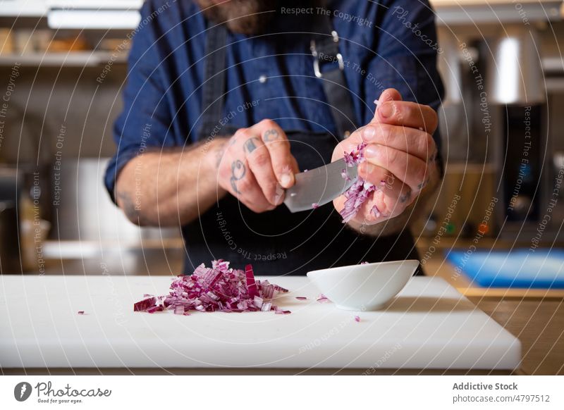 Anonymer Koch beim Zwiebelschneiden in der Küche Mann Küchenchef geschnitten Rezept kulinarisch Bestandteil Messer Schneidebrett vorbereiten männlich frisch