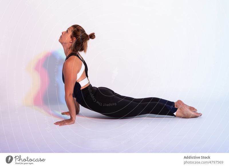Flexible Frau bei der Kobra-Asana Yoga Kobra-Pose bhujangasana Gesunder Lebensstil üben Übung Hobby Training Wohlbefinden anstrengen ausführen mental Schatten