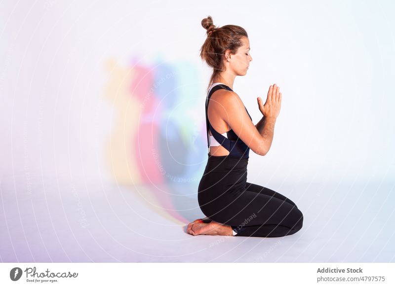 Frau meditiert im Lotussitz meditieren Lotus-Pose padmasana Asana Yoga Achtsamkeit Stressabbau Namaste Gebetshände Zen beten Hände gefaltet Augen geschlossen