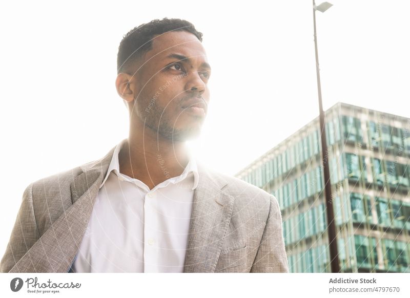 Seriöser schwarzer Geschäftsmann auf der Straße Unternehmer urban Großstadt Business formal Gebäude Stil Vorschein modern gut gekleidet Mann Afroamerikaner