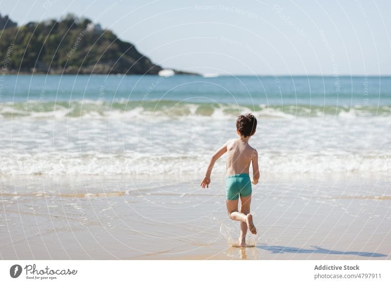 Unbekannter Junge läuft Richtung Meer Kind Strand Sommer Küste Kindheit ruhen MEER laufen sorgenfrei Zeitvertreib Ufer Erholung nackter Torso ohne Hemd Wasser