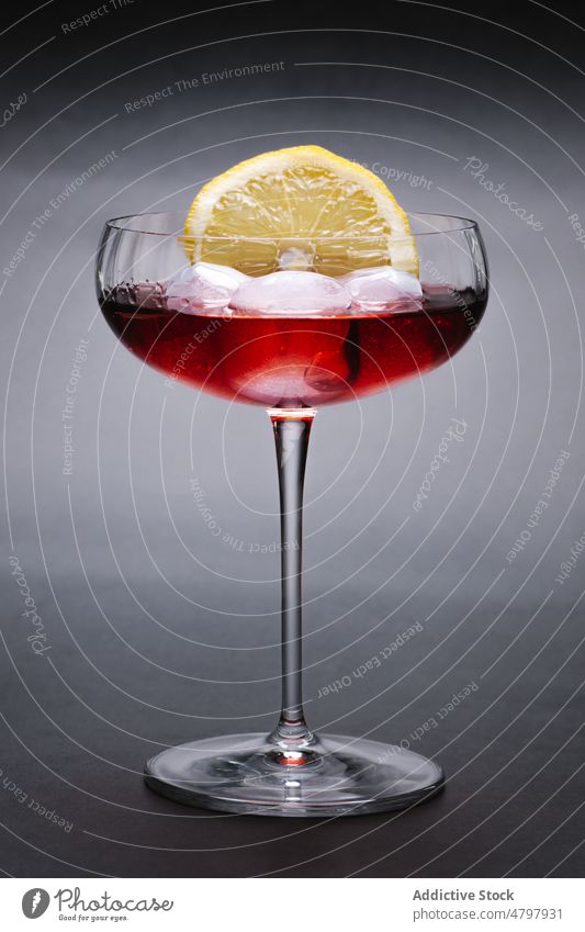 Cocktail mit Eis und Zitrone Weinglas Alkohol Getränk Eiswürfel dienen trinken Aperitif Schnaps Zitrusfrüchte Frucht dekorieren Dekor sauer Scheibe Portion Glas