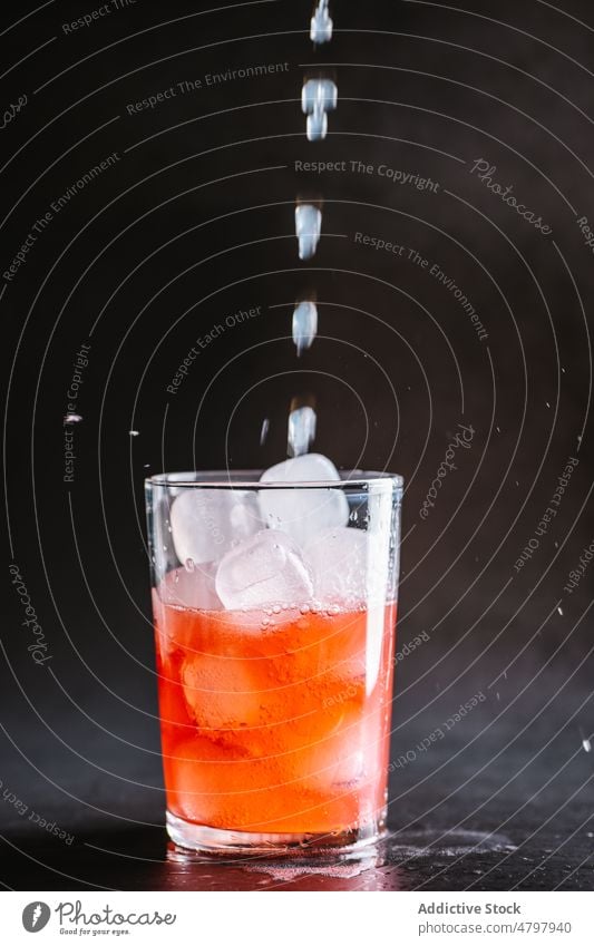 Eis in ein Glas mit Cocktail gießen Alkohol Getränk Eiswürfel dienen trinken Aperitif Zitrone Schnaps Portion durchsichtig kalt liquide Glaswaren Kristalle
