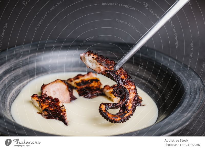 Gebratener Oktopus in Schale mit Sauce Octopus Tentakel Meeresfrüchte dienen gebraten Küche kulinarisch Saucen Speise Mahlzeit Lebensmittel lecker