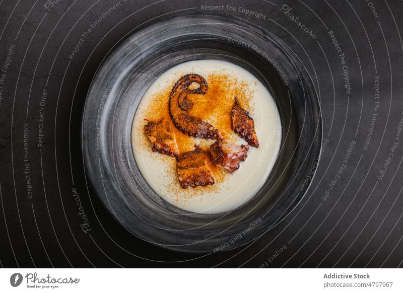 Gebratener Oktopus in Schale mit Sauce und Paprika Octopus Tentakel Meeresfrüchte dienen gebraten Küche kulinarisch Saucen Speise Mahlzeit Lebensmittel