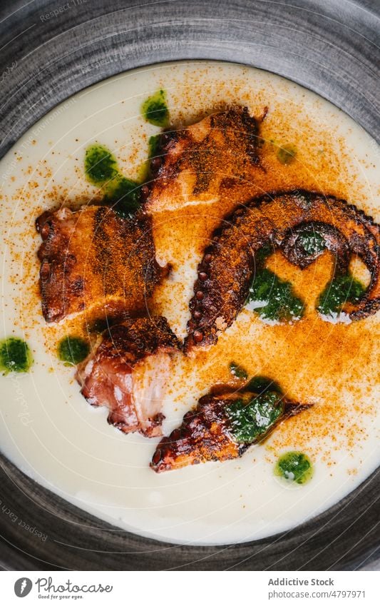 Gebratener Oktopus in Schale mit Sauce und Paprika Octopus Tentakel Meeresfrüchte dienen gebraten Küche kulinarisch Saucen Speise Mahlzeit Lebensmittel