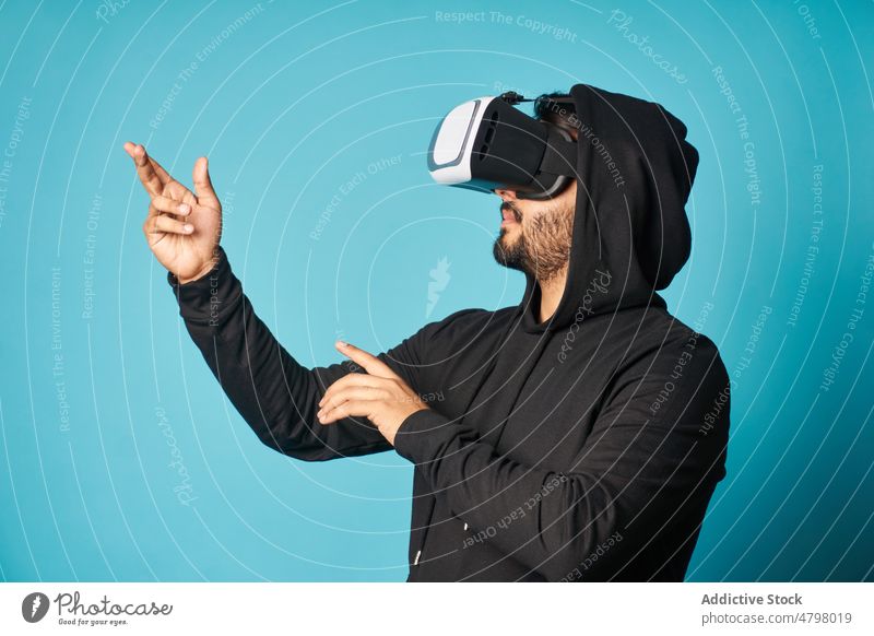 Mann erkundet virtuelle Realität mit Headset VR Schutzbrille Cyberspace Virtuelle Realität futuristisch unterhalten erkunden eintauchen modern Stil lässig