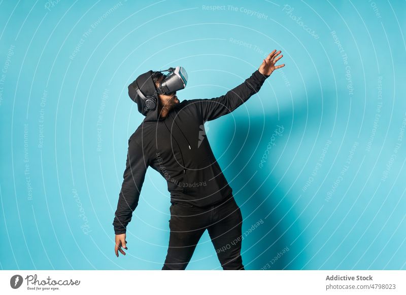Mann erkundet virtuelle Realität mit Headset VR Schutzbrille Cyberspace Virtuelle Realität futuristisch unterhalten erkunden eintauchen modern Stil lässig