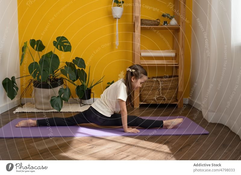 Kind übt Yoga in Spagat-Pose Mädchen Split Achtsamkeit meditieren Asana wenig üben beweglich hanumanasana Fitness Dehnung positionieren Frau Kindheit Zen