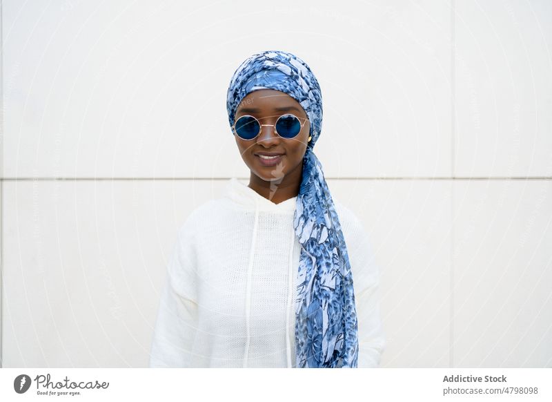 Glückliche stilvolle schwarze Frau mit Kopftuch und Sonnenbrille lächelt in die Kamera Porträt Lächeln selbstsicher Stil cool Mode Inhalt charismatisch trendy