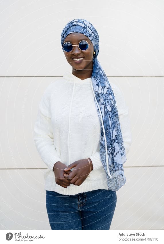 Glückliche stilvolle schwarze Frau mit Kopftuch und Sonnenbrille lächelt in die Kamera Porträt Lächeln selbstsicher Stil cool Mode Inhalt charismatisch trendy