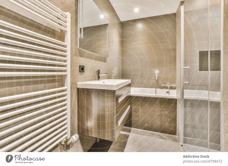 Interieur eines modernen Badezimmers mit Badewanne und Waschbecken Waschraum Stil Innenbereich privat Kübel Design Spiegel Hygiene Licht Waschtisch Appartement