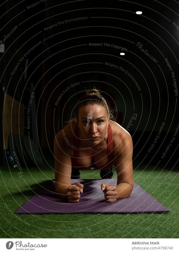 Motivierte junge Sportlerin bei einer Plank-Übung im Fitnessstudio Schiffsplanken Training Motivation Konzentration Athlet passen Frau Gesundheit brünett