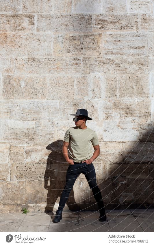 Stilvoller Mann in der Nähe einer schäbigen Wand Straße Großstadt urban Mode Design Hut Kopfbedeckung Kopfschmuck Revier Gebäude trendy Vorschein verwittert