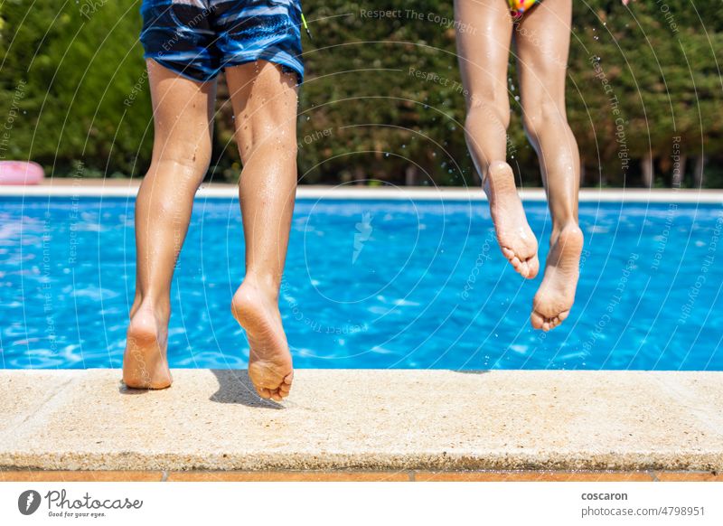 Zwei kleine Kinder springen in ein Schwimmbecken. Detail Bein Aktivität schön blau Kindheit Saum Fuß Freiheit frisch Spaß Mädchen Fröhlichkeit Glück Gesundheit
