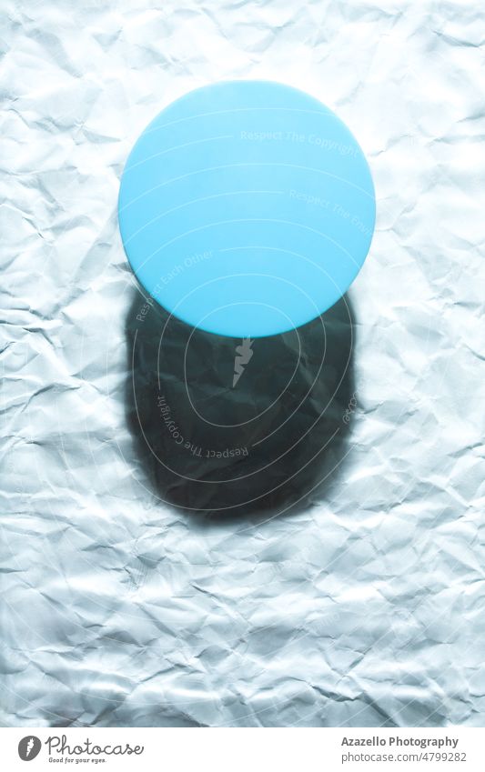 Rundes blaues Objekt auf abstraktem blauem Hintergrund. Minimalist flach legen einzelne Objekt mit Schatten. Stillleben Minimalismus Wasser nass Unschärfe