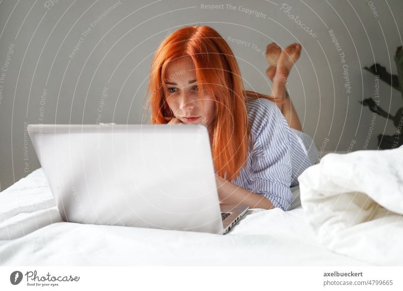 Junge Frau auf dem Bett liegend mit Laptop-Computer jung Lügen sich[Akk] entspannen zu Hause zuschauend Streaming Film Video Talkrunde Webcam Schlafzimmer