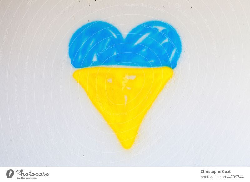 Besprühte ukrainische Flagge in Form eines Herzens Sprühfarbe keine Menschen Straßenkunst Graffitti Wand horizontal Fotografie Krieg Hoffnung Liebe