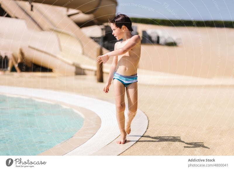 Kleiner Junge steht in der Nähe von Schwimmbad am sonnigen Tag Pool Beckenrand schwimmen bereit vorbereiten Sommer Urlaub Wochenende Kind aktiv Feiertag Resort