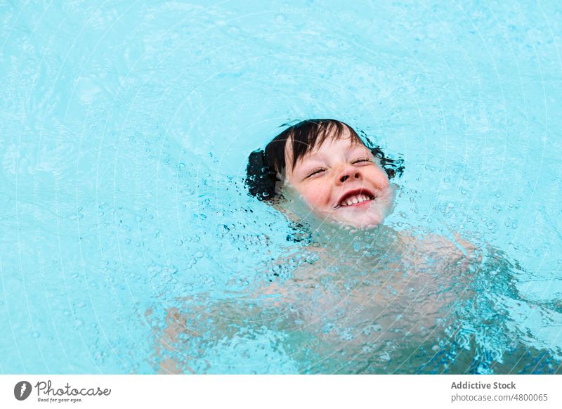 Entzückendes Kind schwimmt im Pool an einem sonnigen Tag schwimmen Sommer Feiertag Kindheit Aktivität genießen Junge Wasser Urlaub Resort niedlich nasses Haar