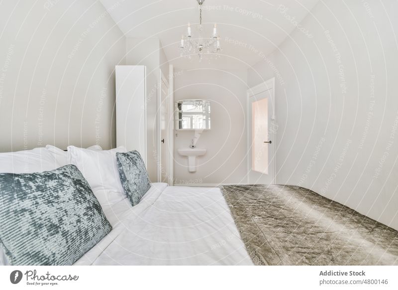 Bequemes Bett in einem modernen Schlafzimmer mit verschiedenen Dekorationen Innenbereich Teppich geräumig Komfort Stil Appartement Möbel gemütlich wohnbedingt