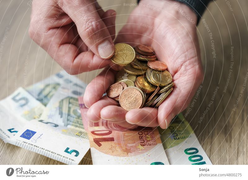 Ein Mann hält Euro Geldmünzen in den Händen Geldscheine Hand halten Bargeld Finanzen sparen Münzen Kapitalwirtschaft Einkommen bezahlen Reichtum Investition
