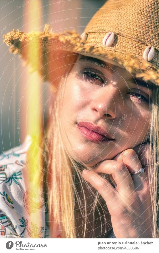 Porträt mit Lichteffekt einer jungen schönen Blondine mit grünen Augen und Strohhut Nahaufnahme hübsch Hut Lifestyle Menschen attraktiv Junge Frau Mädchen