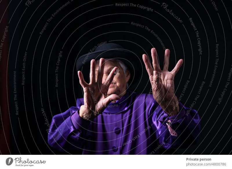 Handfläche einer alten Frau auf schwarzem Hintergrund. 80s Missbrauch gegen Lebensalter Aggression Alterung Arthritis Körper Kaukasier schließen Nahaufnahme