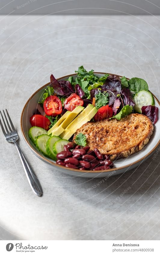 Schüssel mit grünem Salat und einer Scheibe Brot Salatbeilage Tomate Lebensmittel Gesundheit frisch Rucola Mahlzeit Diät Gemüse Vegetarier Teller Mittagessen