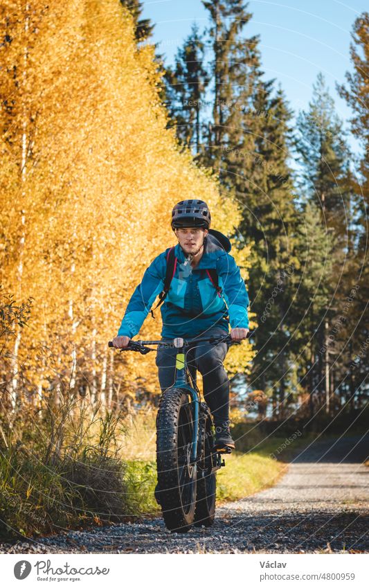 Ein Freizeitradler fährt bei schönem Herbstwetter und Sonnenuntergang durch die Vuokatti-Arena. Erkundung der Gegend auf Fatbikes. Finnische Landschaft