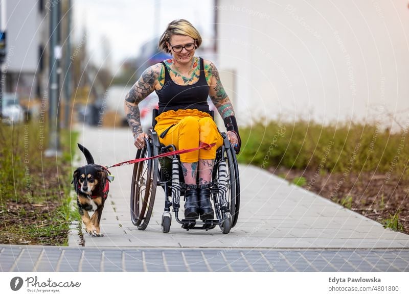 Frau im Rollstuhl mit ihrem Hund im Freien häusliches Leben Selbstvertrauen im Innenbereich heimwärts Haus Menschen jung Erwachsener lässig Kaukasier attraktiv