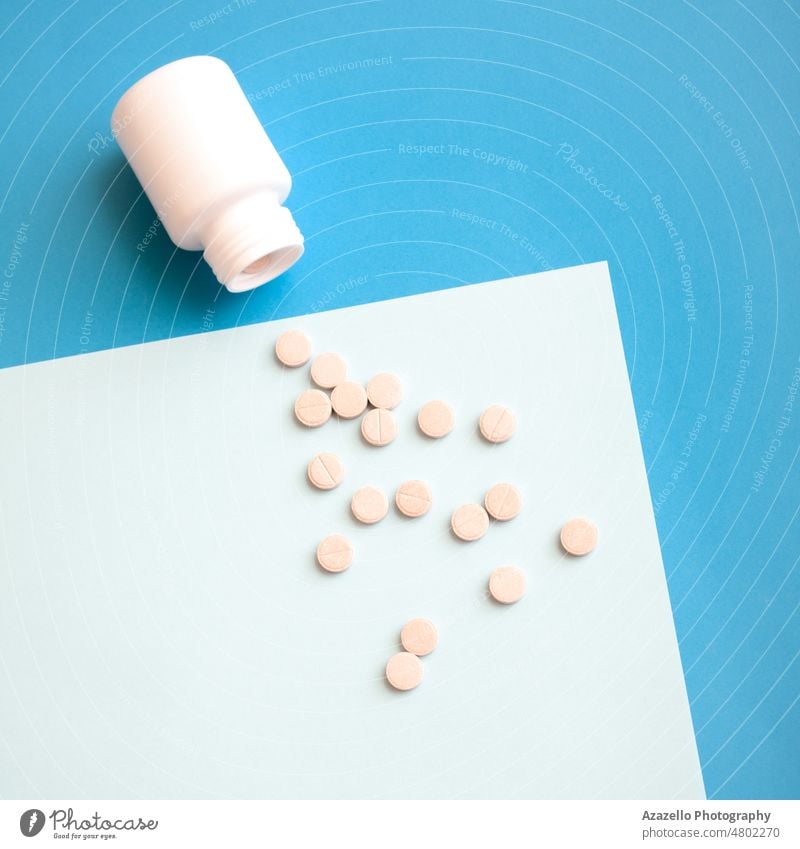 Weiße Plastikflasche und Pillen auf blauem Hintergrund Medikamente Medizin Chemie Pharma weiß Tablette Dosis Verschreibung Flasche Container Spritze
