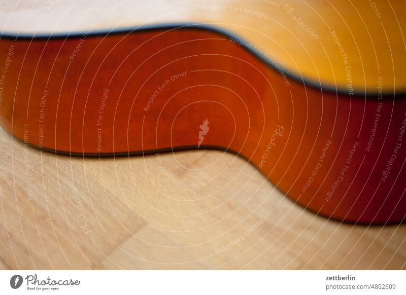 Seitenansicht einer Gitarre Saiteninstrumente bund decke folk folklore gitarre hals hausmusik holz instrumentenbau liegen musikinstrument perle saite