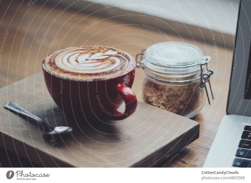 Cappuccino in einer roten Tasse und einer Dose mit Müsli Tasse Kaffee rote Kaffeetasse Kaffeebar Espresso Frühstück warmes Getränk gemütlich Morgen Lebensmittel