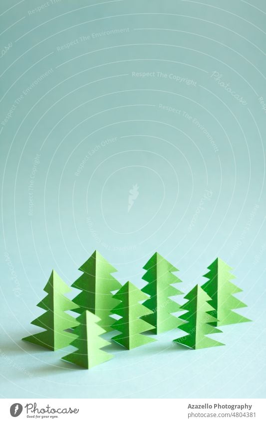 Papierwald mit freiem Platz zum Kopieren und Einfügen von Text. Grüne Papierbäume auf blauem Hintergrund. abstrakt Konzept konzeptionell kreativ Design