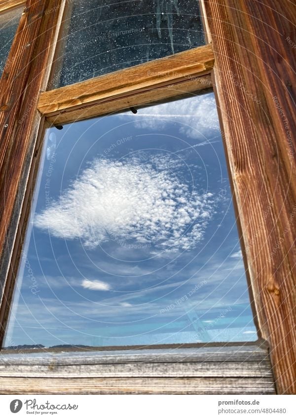 Wolkenspiegelung im Fenster einer Hütte in den Allgäuer Alpen nahe dem Riedberger Horn / Foto: Alexander Hauk Spiegelung fenster hütte himmel blau weiß allgäu