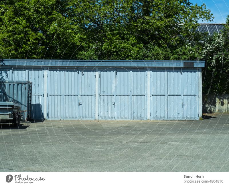 hellblaue Tore Hinterhof Lager Container Garage Beton Einfahrt geschlossen Aufbewahrung Lagerfläche Garagentor Versteck Fassade Ausfahrt alt Parkplatz