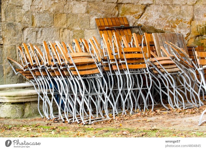 Zusammengeklappt und weggestellt untergestellt Gartenstühle zurückstellen Sommerzeit Sommerzeitende zusammengeklappt leer Menschenleer Stuhl Außenaufnahme
