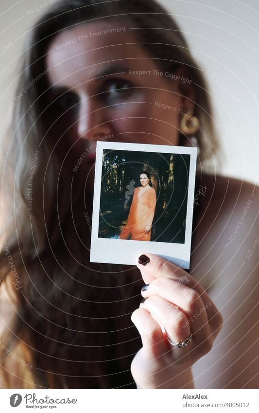 Junge Frau hält Polaroid Bild von sich in die Kamera junge Frau schön feminin weiblich schlank Identität analog analoges Bild Filmfotografie authentisch