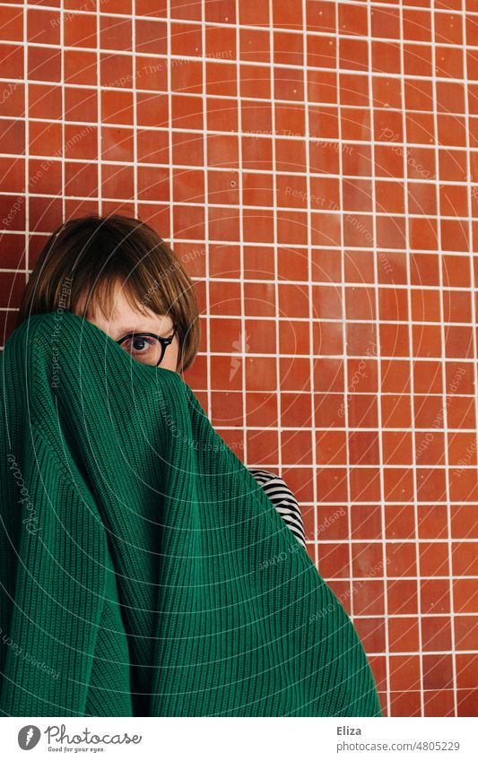 [hansa BER 2022] Frau vor roter Wand versteckt sich hinter grüner Strickjacke verstecken schüchtern feminin Porträt hervorgucken Scham schämen Mensch Angst