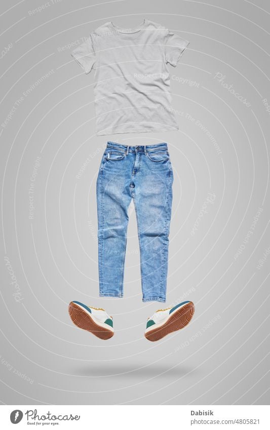 Fliegende Kleidung auf grauem Hintergrund für Mockup. Stoff T-Shirt Jeanshose Mode Attrappe lässig Schuhe Hemd Werkstatt vereinzelt Jeansstoff Vorlage weiß