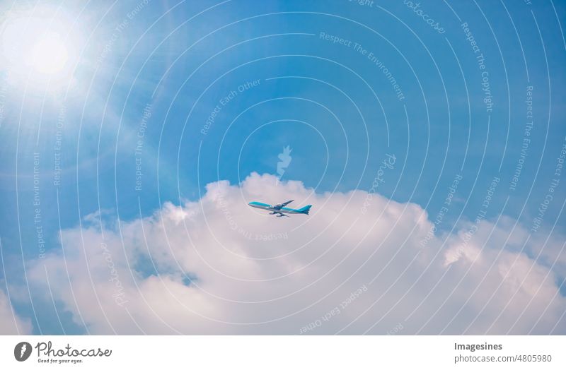 Flugzeug im Hochflug, blauer Himmel und Wolken mit Sonne und Sonnenstrahlen. Verkehrsflugzeug, das in Richtung Wolken im blauen Himmel fliegt. Silhouette von Flugzeugen, die in den Wolken fliegen. von unten