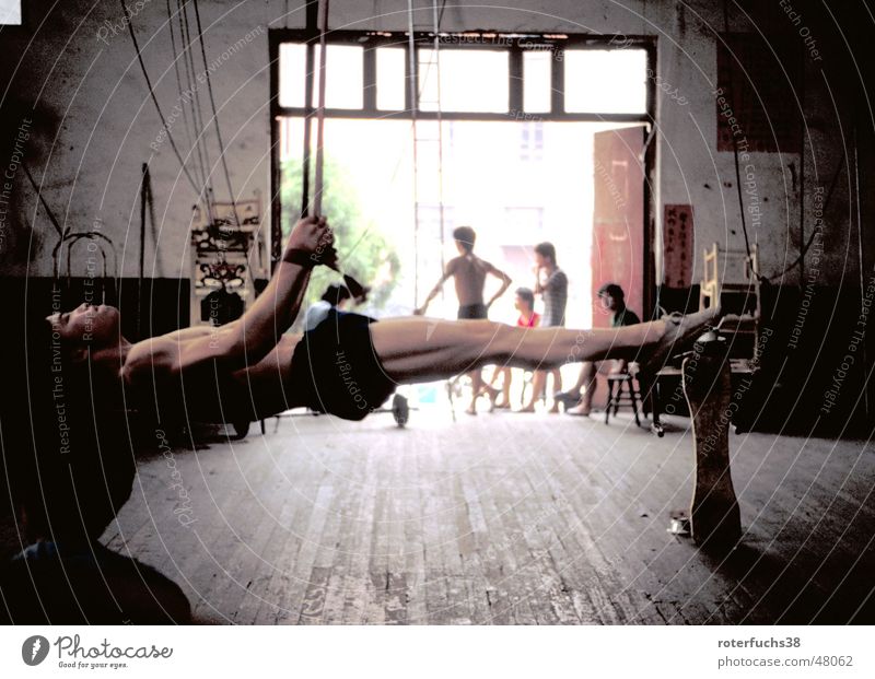 Artist in Shengdu china Sporthalle Holzfußboden Chengdu China horizontal Turnhose Turnen Turner Mangel unmöglich anstrengen Bodybuilder Zirkuskind Kommunismus