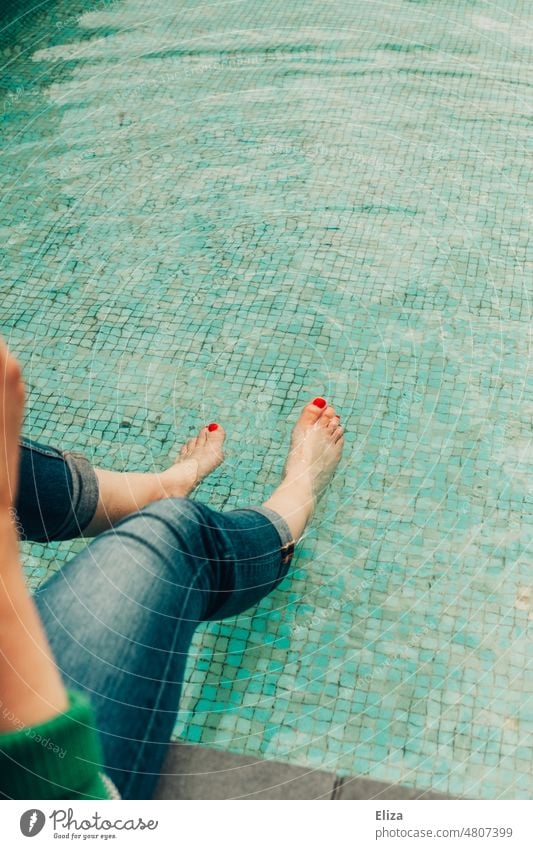 [hansa BER 2022] Frau in Jeans kühlt ihre, mit rotem Nagellack verzierten, Füße in einem Wasserbecken ab Zehen Zehennägel Becken planschen abkühlen Barfuß