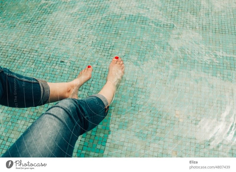 [hansa BER 2022] Frau in Jeans kühlt ihre, mit rotem Nagellack verzierten, Füße in einem Wasserbecken ab Zehen Zehennägel Becken planschen abkühlen Barfuß