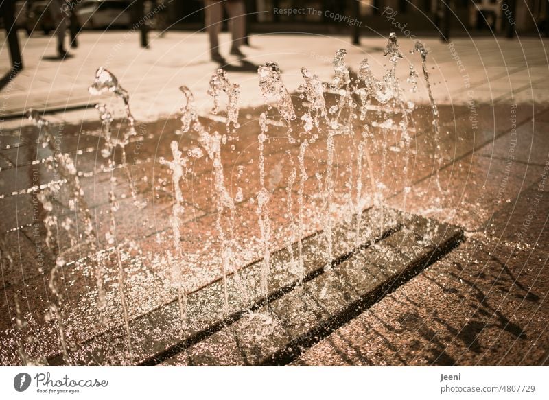 Wasserspiel auf einem Marktplatz Wassertropfen gepflastert Stadt Stadtzentrum Sonne Sonnenlicht nass Schatten Licht Springbrunnen spritzen Wasserfontäne kalt