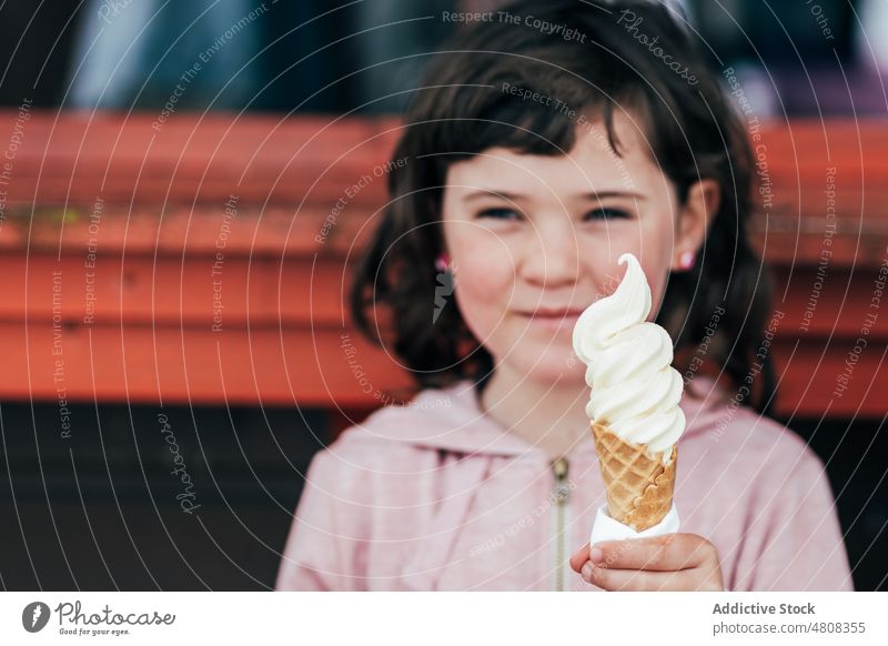 Mädchen isst Eiscreme Speiseeis lutschen Lächeln Straße Kassenhaus Sommer Wochenende Porträt süß Kind Dessert niedlich lecker bezaubernd Kindheit wenig tagsüber