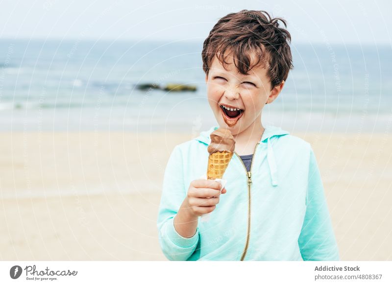 Lächelnder Junge isst Schokoladeneis Speiseeis lutschen Sommer Wochenende Strand Porträt süß Kind Seeküste Dessert niedlich lecker Urlaub bezaubernd Kindheit